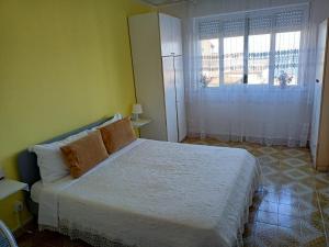 a bedroom with a bed and a large window at stanza vista mare in Giardini Naxos