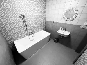 a bathroom with a white tub and a sink at TGM Apartments in Český Krumlov