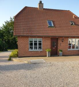a red brick house with a red roof at Lejlighed vest for Christiansfeld in Christiansfeld