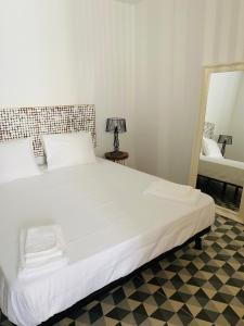uma grande cama branca num quarto com um espelho em A Casa Azul em Santa Luzia