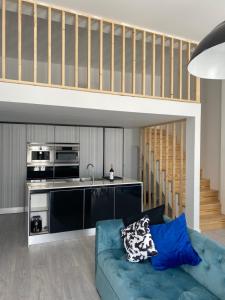 a living room with a blue couch and a kitchen at A Casa Azul in Santa Luzia