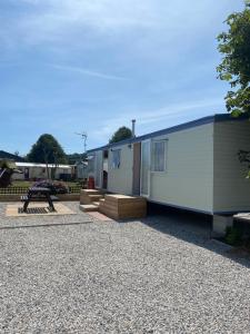 a mobile home with a picnic table and a bench at G3 Holiday Caravan in Par