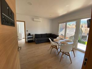 ein Wohnzimmer mit Tisch und Stühlen und einer Couch in der Unterkunft Apartamentos Turisticos Costa Celeiro: Portomaior, Agrelo, Covelo Lapamán in Bueu