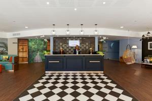 a lobby with a checkered floor at Hôtel Birdy by Happyculture in Aix-en-Provence