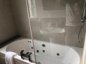 a bathroom with a bath tub and a sink at Brecbennoch in Oban