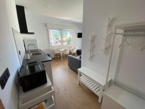 ein weißes Wohnzimmer mit einer Küche und einem Wohnzimmer in der Unterkunft Apartamentos Turisticos Costa Celeiro: Portomaior, Agrelo, Covelo Lapamán in Bueu