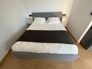 ein Schlafzimmer mit einem Bett mit einer schwarzen Decke und weißen Kissen in der Unterkunft Apartamentos Turisticos Costa Celeiro: Portomaior, Agrelo, Covelo Lapamán in Bueu