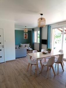 a dining room and living room with a table and chairs at Gîte Les Demoiselles des Sorgues in L'Isle-sur-la-Sorgue