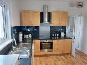 a kitchen with a sink and a stove top oven at Cuddys Corner in Beadnell
