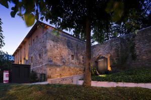 um edifício de tijolos com uma árvore em frente em Dauria Suites HA em Soria