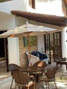 a table and chairs with an umbrella on a patio at Ateliê 22 in Natal