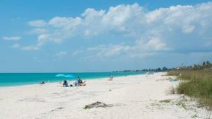 a group of people on a beach near the ocean at Near Venice Beach, sleeps 6, walk to river in Nokomis