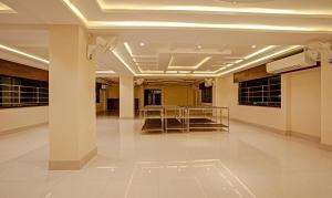 a lobby with tables and chairs in a building at Treebo Trend Indrapuri Hotel & Resort Siliguri Junction in Siliguri
