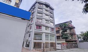 西里古里Treebo Indrapuri Hotel & Resort, Siliguri Junction的一座挂着招牌的高大白色建筑