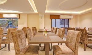 Treebo Trend Indrapuri Hotel & Resort Siliguri Junction في سيليغري: غرفة طعام مع طاولة وكراسي