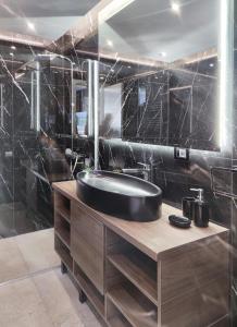 Baño negro con bañera y lavamanos en Casa Palmera en Novi Sad