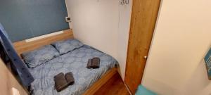 een kleine slaapkamer met een bed met slippers erop bij Tiny House Miniş in Miniş