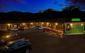 un motel avec des voitures garées dans un parking la nuit dans l'établissement Hotel Rural "La Ruta De Cabrales", à Mestas de Con