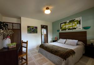 a bedroom with a bed and a table and a desk at Hotel Rural "La Ruta De Cabrales" in Mestas de Con