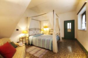 a bedroom with a canopy bed and a couch at Il Chicco d'Oro in Massarosa