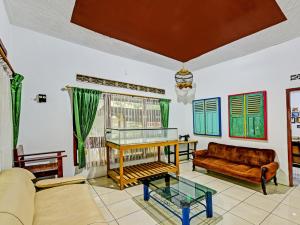 uma sala de estar com um sofá e uma mesa em SPOT ON 91372 Wisma Bulin em Purwokerto