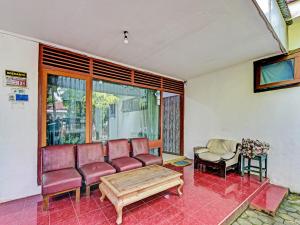 a room with a couch and a table and a chair at SPOT ON 91372 Wisma Bulin in Purwokerto