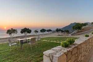 a patio with a table and chairs overlooking the ocean at Mathios apartments Falassarna in Falasarna