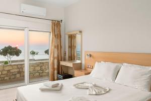 a bedroom with a bed with a view of the ocean at Mathios apartments Falassarna in Falasarna
