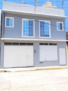 a house with two garage doors on a street at Departamento Anel en Huatulco in Santa Cruz Huatulco