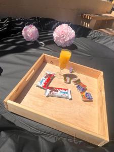 a wooden tray on a bed with a glass of orange juice at Bulle insolite Fréjus in Fréjus