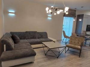a living room with a couch and a table and chairs at Apartamentai in Garliava