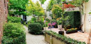 um jardim com um ramo de plantas e flores em R&breakfast em Roeselare