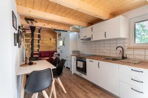 a kitchen with white cabinets and a table and chairs at Lavender Lodge Bled in Bled