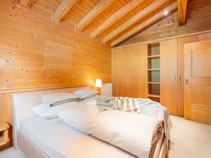 sypialnia z dużym łóżkiem w drewnianej ścianie w obiekcie Charming holiday home in Maurach am Achensee w mieście Maurach