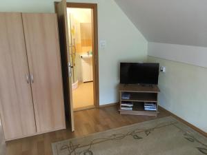 ein Wohnzimmer mit einem TV und einem Badezimmer in der Unterkunft Apartmány Smrečie in Bukovina