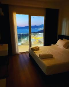 a bedroom with a bed and a large window at SEA & LAKE VIEW VILLA in (( Kalive Gjoka ))