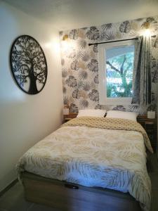 a bedroom with a bed with a tree mural at La Terrasse Ensoleillée de Sausset : Le Citronnier in Sausset-les-Pins