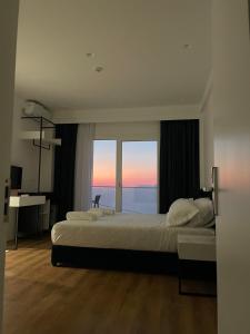 a large bedroom with two beds and a large window at SEA & LAKE VIEW VILLA in (( Kalive Gjoka ))