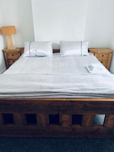 a bedroom with a wooden bed with white sheets and pillows at 21 ,North Street in Shrewsbury