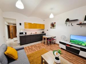 uma sala de estar com um sofá, uma televisão e uma cozinha em Ground Floor Apartment em Praga