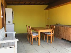 eine Küche mit einem Holztisch und Stühlen im Zimmer in der Unterkunft Sazava River Cottage with boating experience in Týnec nad Sázavou