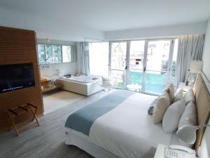 a large bedroom with a large bed and a tub at CasaCalma Hotel in Buenos Aires