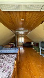 a large room with two beds and a wooden floor at Saulėtekio 12 in Ignalina
