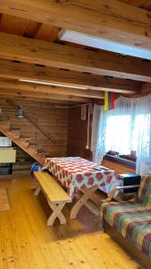 ein Zimmer mit einem Tisch und einer Bank in einer Hütte in der Unterkunft Saulėtekio 12 in Ignalina