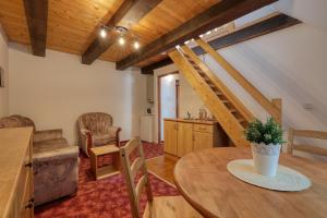 a living room with a table and a staircase at RAMZOVKA - bývalý penzion Anna in Ramzová