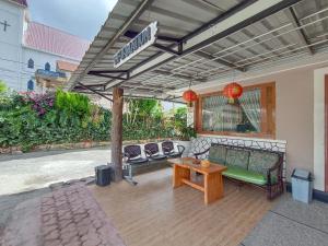 a patio with a bench and a table and chairs at Hotel New Dieng By Helocus in Berastagi