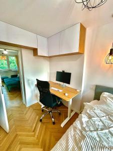 a room with a desk and a bed and a computer at Luxurious BOHO style apartm. *HOME OFFICE* +Desk in Katowice