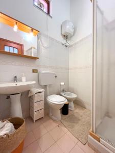 La salle de bains est pourvue de toilettes, d'un lavabo et d'une douche. dans l'établissement SURFING COTTAGES, à Gizzeria