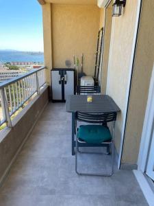 a balcony with a table and chairs on a balcony at Le Pélican Magnifique F2 in Ajaccio