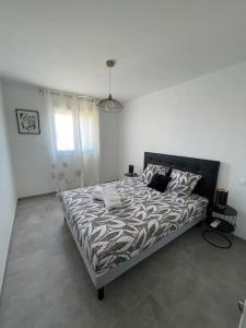 um quarto com uma cama grande num quarto branco em Le Pélican Magnifique F2 em Ajaccio